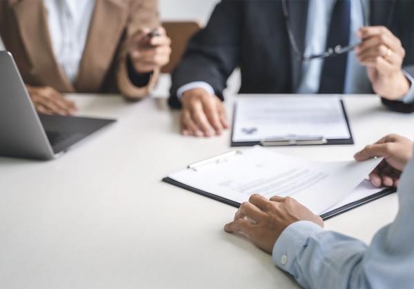 hands on table with resume and laptop